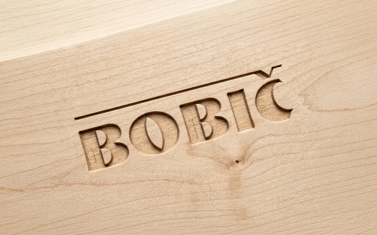 The wordmark engraved into wood
